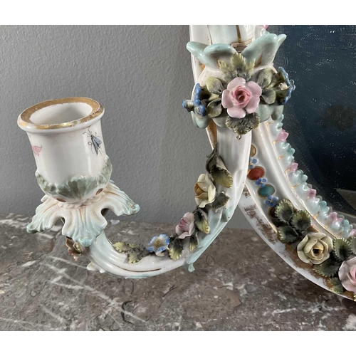 1232 - A Sitzendorf porcelain wall mirror, with twin candle sconces and floral encrusted border, surmounted... 