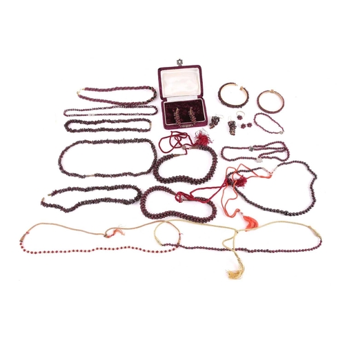 1296 - A large collection of garnet beaded jewellery; including four drawstring necklaces with adjustable c... 