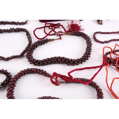 1296 - A large collection of garnet beaded jewellery; including four drawstring necklaces with adjustable c... 