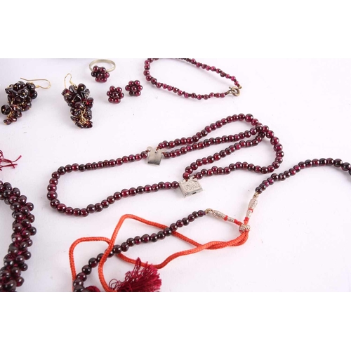 1296 - A large collection of garnet beaded jewellery; including four drawstring necklaces with adjustable c... 