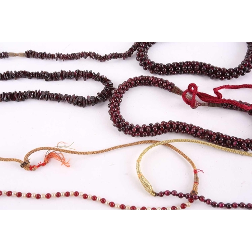 1296 - A large collection of garnet beaded jewellery; including four drawstring necklaces with adjustable c... 