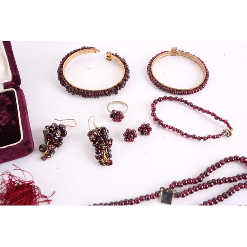 1296 - A large collection of garnet beaded jewellery; including four drawstring necklaces with adjustable c... 