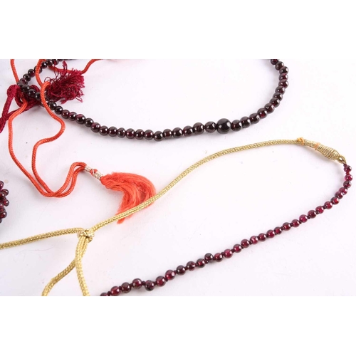 1296 - A large collection of garnet beaded jewellery; including four drawstring necklaces with adjustable c... 