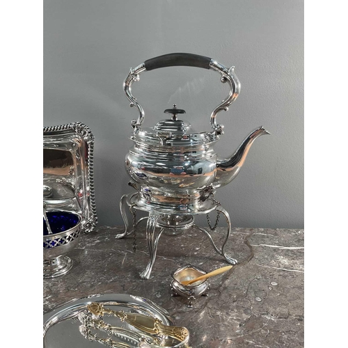 1326 - A quantity of silver-plated items, to include a spirit kettle on stand, a chamber stick, spoons, dis... 