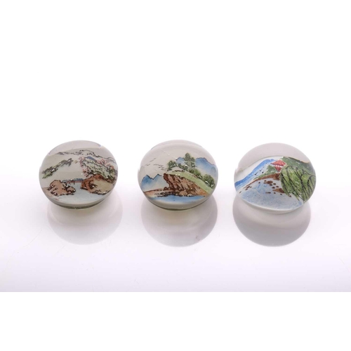 40 - A collection of three 'Chinese White' paperweights featuring landscape scenes of varying seasons, al... 
