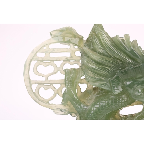 1235 - A contemporary Chinese variegated celadon jade carved and pierced study of two writhing dragons cont... 