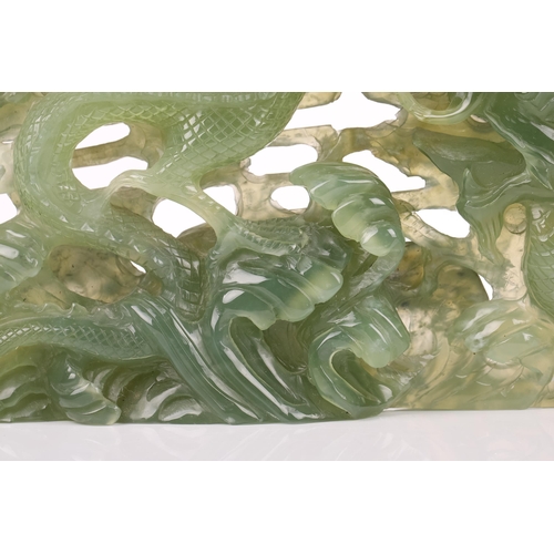 1235 - A contemporary Chinese variegated celadon jade carved and pierced study of two writhing dragons cont... 