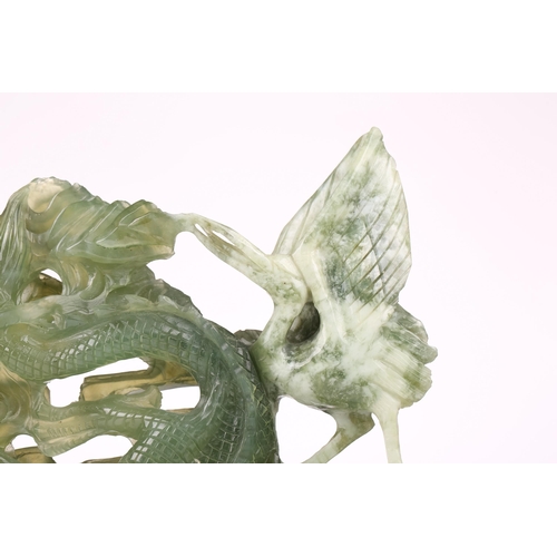 1235 - A contemporary Chinese variegated celadon jade carved and pierced study of two writhing dragons cont... 