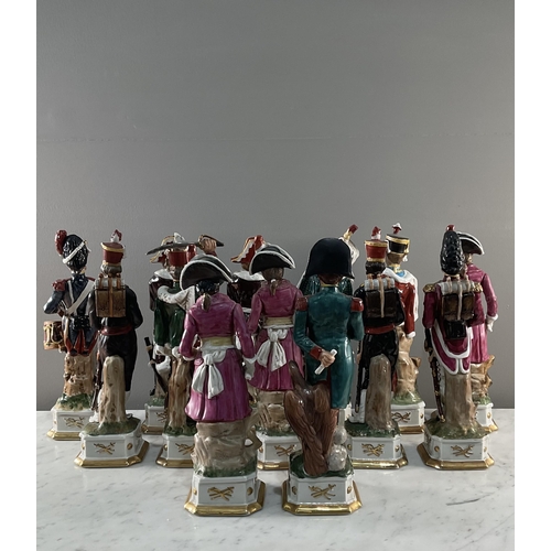 1287 - A collection of thirteen continental porcelain figures of French soldiers, including Napoleon, on sc... 