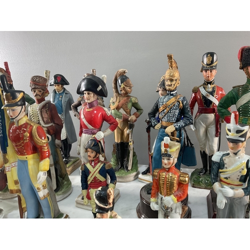 1295 - A large collection of both porcelain and resin continental figures of soldiers, of varying size and ... 