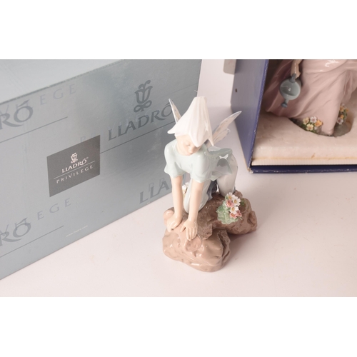 102 - A collection of two boxed Lladro figures, one of girl with flowers, signed to base with original pap... 