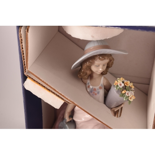 102 - A collection of two boxed Lladro figures, one of girl with flowers, signed to base with original pap... 