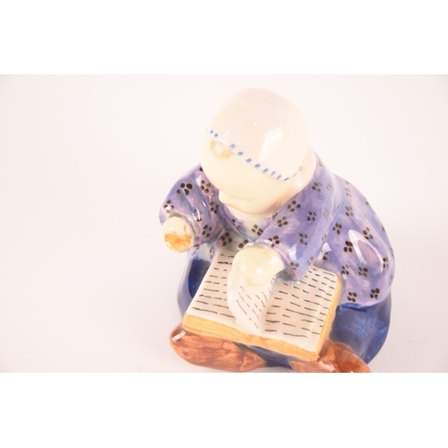 113 - A Quimper ceramic figure of a young child with a book, signed 'B.Savigny', 11.5 cm high.