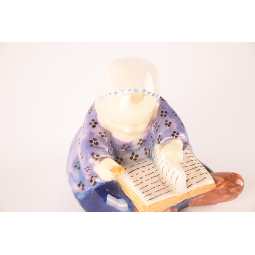 113 - A Quimper ceramic figure of a young child with a book, signed 'B.Savigny', 11.5 cm high.