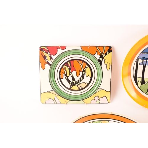 121 - After Clarice Cliff; a collection of decorative plates comprising two rectangular plates from the Ar... 