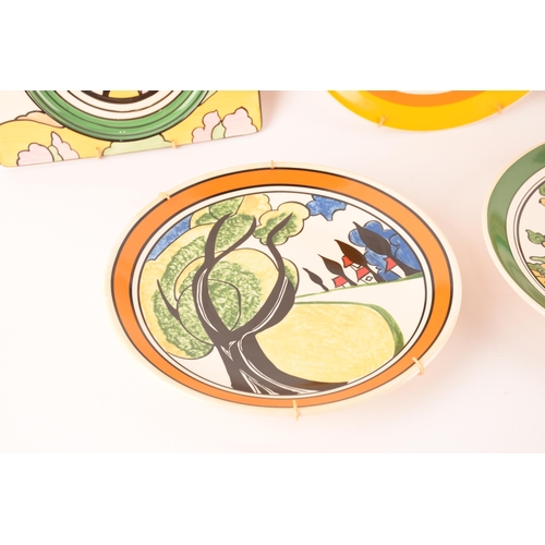 121 - After Clarice Cliff; a collection of decorative plates comprising two rectangular plates from the Ar... 