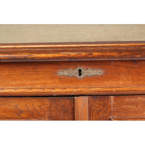 36 - A late Victorian oak clerk's desk, the high hinged slope over a pair of panelled doors, enclosing pi... 