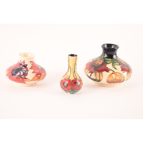 76 - A collection of Moorcroft vases comprising short vase with red and magenta decoration on white groun... 