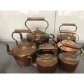 Seven various copper kettles.