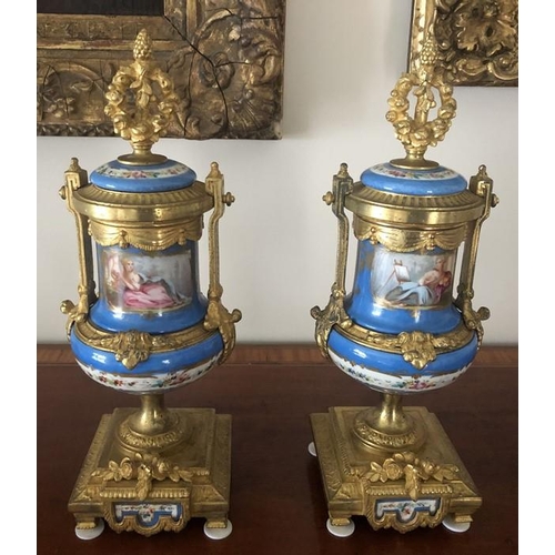 1064 - A pair of 19thC hand painted gilt mounted porcelain urns. 35cms h. Marked to the rear Brunfaut.