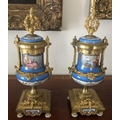 A pair of 19thC hand painted gilt mounted porcelain urns. 35cms h. Marked to the rear Brunfaut.