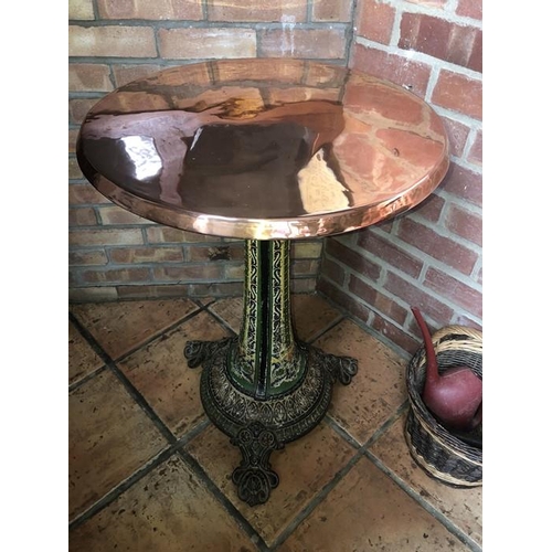 1443 - A cast iron and copper table, 79cms h, top 55cms d.