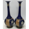 Pair of Royal Doulton stoneware slim neck vases, blue ground with tubeline floral decoration, 29cms.... 