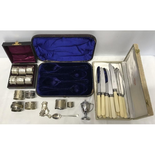 506 - A selection of silver plated napkin rings including a cased set of Parisian souvenir, bracelet, must... 