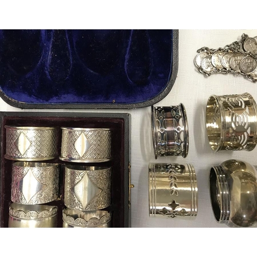 506 - A selection of silver plated napkin rings including a cased set of Parisian souvenir, bracelet, must... 