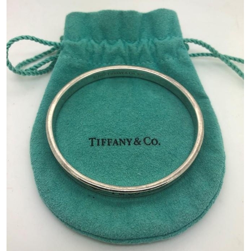 541 - A vintage Tiffany silver bangle of typical round form with engraved T & Co, the interior marked 1997... 