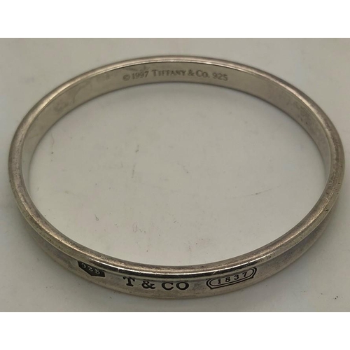 541 - A vintage Tiffany silver bangle of typical round form with engraved T & Co, the interior marked 1997... 