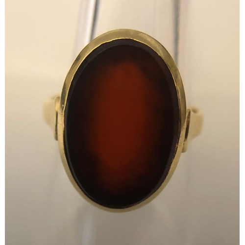 563 - A single stone oval cabochon cut Carnelian ring stamped 14ct, yellow gold, size O, 4.23gms.