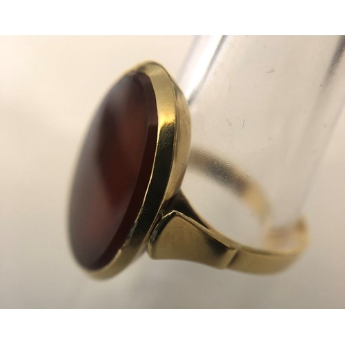 563 - A single stone oval cabochon cut Carnelian ring stamped 14ct, yellow gold, size O, 4.23gms.