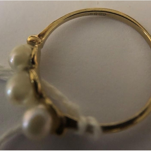 568 - A 9ct yellow gold ring set with 3 pearls, size N/O. 1.3gms.