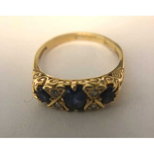 569 - A 3 stone sapphire and diamond ring in 18ct yellow gold, size N. 3.1gms.