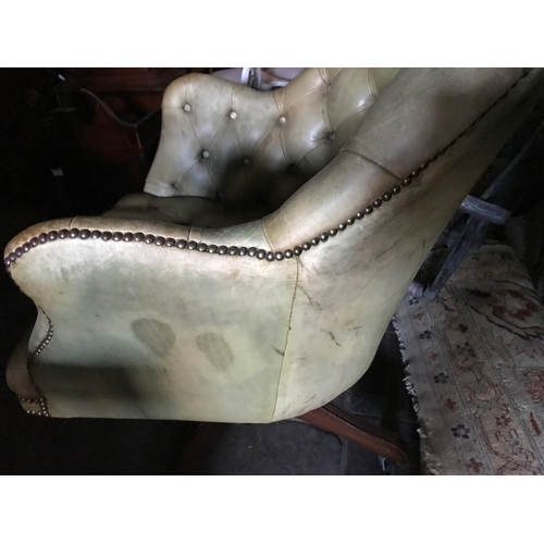 1386 - A green buttoned leather armchair.