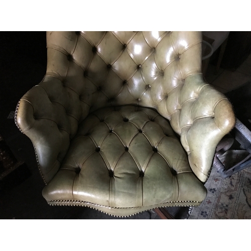 1386 - A green buttoned leather armchair.