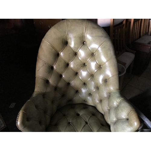 1386 - A green buttoned leather armchair.