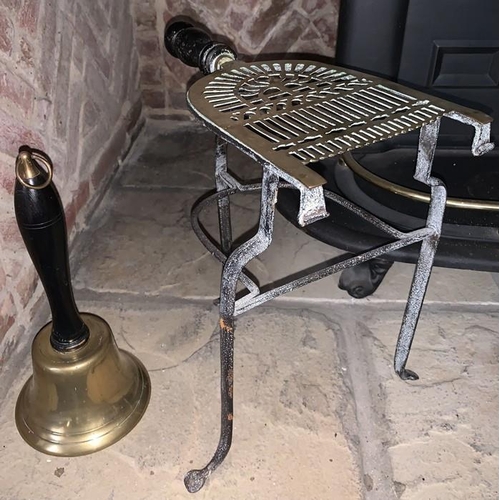 1163 - A 19thC brass & iron trivet with brass hand bell. 49cms h.