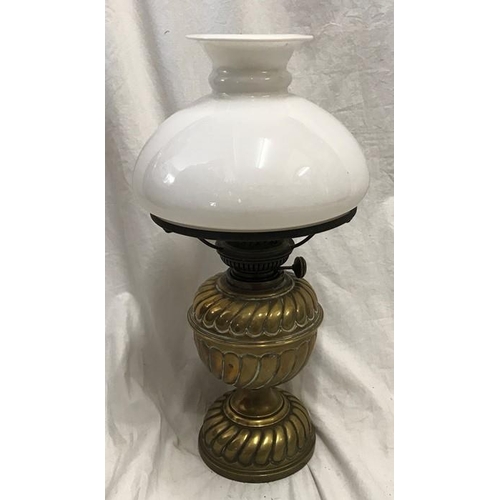 1180 - A Victorian brass oil lamp with milk glass shade, 43cms h with chimney flute.