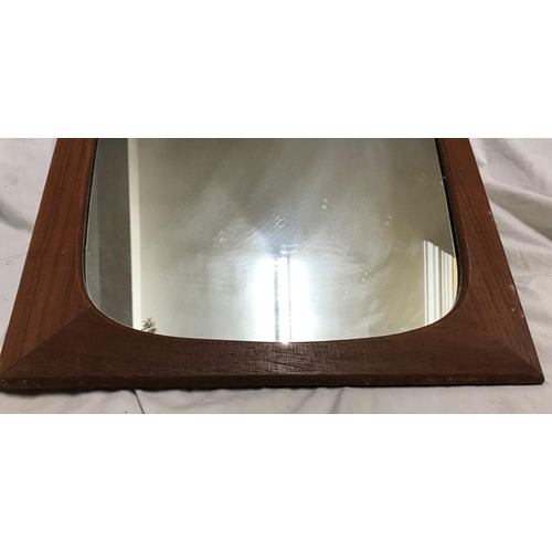 1197 - A 1970's teak framed rectangular wall mirror. 70 h x 31cms w at the bottom, 39cms w at the top.