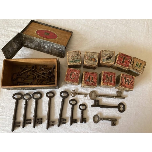 1274 - A vintage metal cigarette box containing various keys and 9 19thC child's building blocks.