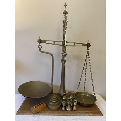 1276 - Set of brass balance scales and weights on mahogany base including 5 bell weights.