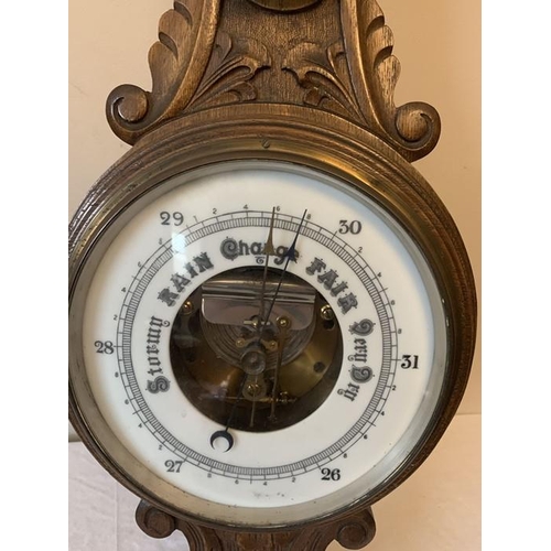 1287 - An oak cased aneroid barometer with carved body, 87cms h.