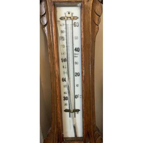 1287 - An oak cased aneroid barometer with carved body, 87cms h.