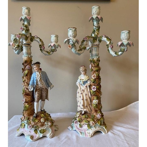 230 - Two 19thC candelabra 54cms h . Male and female with three scroll branches on decorated foliated colu... 