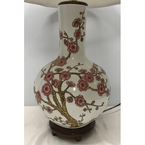 260 - Chinese pottery table lamp on carved wooden base, Cherry Blossom pattern. Lamp 39cms h with shade 67... 