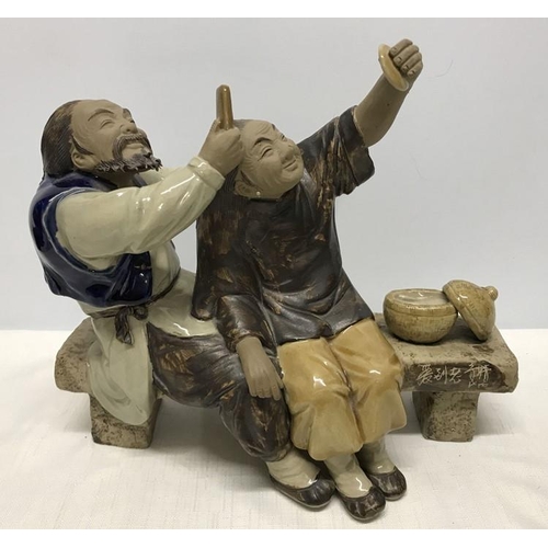 265 - Chinese ironstone pottery figurine, Man combing ladies hair sat on a bench, signed to bench front, s... 