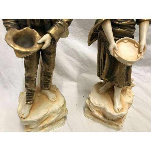 322 - Pair of continental porcelain figurines. Gilt and ivorine effect, street musicians, 34cms h.