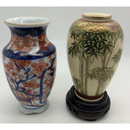 368 - Two Oriental vases and a wooden stand 9.5cms h and 10.5cms h.